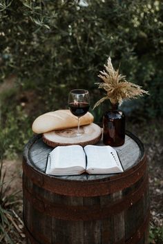 a wine glass and book sitting on top of a barrel