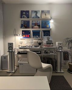 a white chair sitting in front of a computer desk with speakers on top of it