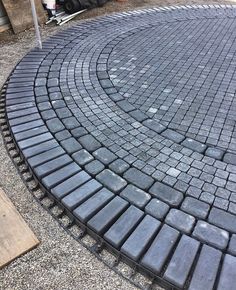 a circular brick patio being built in front of a house