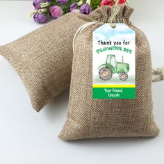 two burlap bags with farm themed tags on them and flowers in the background