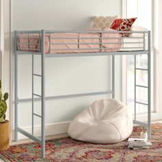 a white bunk bed sitting on top of a rug next to a potted plant