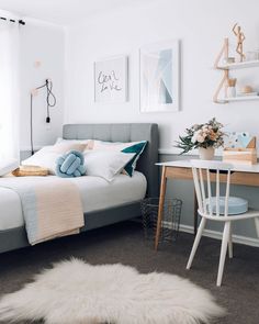 a bedroom with a bed, desk and pictures on the wall