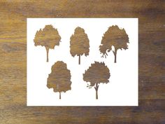 four trees are shown on a wooden surface