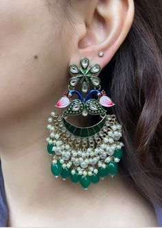 These beautiful Kundan earrings are the perfect accessory to brighten up your outfit. They are lightweight and high quality, and sure to become a staple in your jewellery collection.  Available in 3 beautiful colours: lilac purple, dark green and hot pink.  In case of any queries, please feel free to contact us. Happy shopping! Kundan Earrings With Peacock Design For Celebrations, Elegant Peacock Design Chandelier Earrings For Festive Occasions, Green Pearl Earrings For Celebration, Green Pearl Earrings For Festive Celebrations, Elegant Festive Chandelier Earrings With Peacock Design, Festive Green Pearl Earrings For Celebration, Green Peacock Design Earrings For Wedding, Kundan Earrings With Peacock Design For Weddings, Chandbali Peacock Design Bridal Earrings For Celebrations