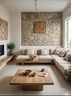 a living room filled with lots of furniture and a stone wall behind the couches