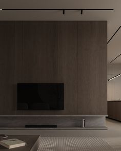 an empty living room with a large flat screen tv on the wall and wooden paneling