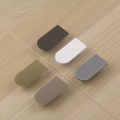 four different colors of magnets sitting on top of a wooden floor