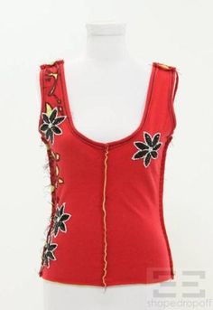 a woman's red top with black and white flowers on the front, along with gold trimmings