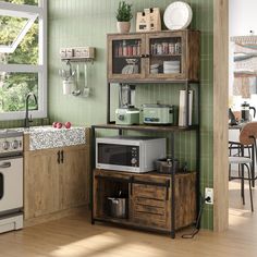 a kitchen with green walls and wood floors, including a microwave oven on top of a wooden shelf