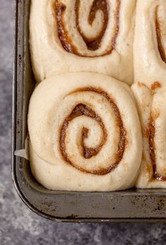 four cinnamon rolls sitting in a pan on top of a counter