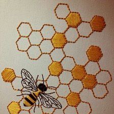 two bees are sitting on the honeycombs that have been embroidered onto each other