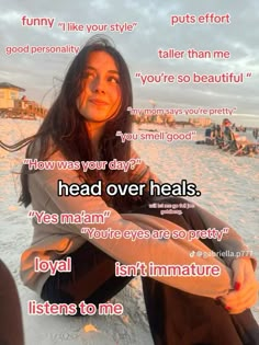 a woman sitting on top of a beach next to the ocean with words above her