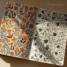 an open notebook with orange and black designs on the cover, sitting on a table