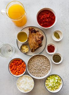 several bowls with different types of food in them next to a pitcher of orange juice