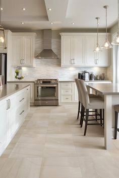 a large kitchen with white cabinets and stainless steel appliances in the center, along with marble flooring