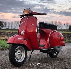 a red scooter parked on the side of a road