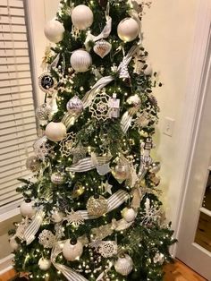 a christmas tree decorated with silver and white ornaments