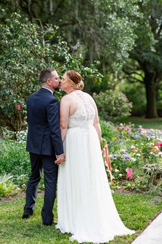 a bride and groom kissing in the garden