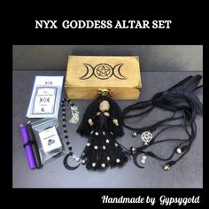 an assortment of items are displayed on a table with the caption nyx goddess altar set