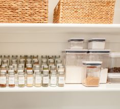 the shelves are full of spices and containers with labels on them, along with wicker baskets