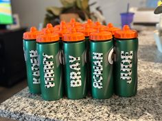 six green and orange soda bottles sitting on top of a counter