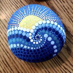 a painted rock sitting on top of a wooden table