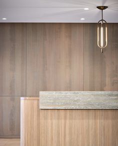 an empty room with wood paneling and a light fixture hanging from the ceiling above it