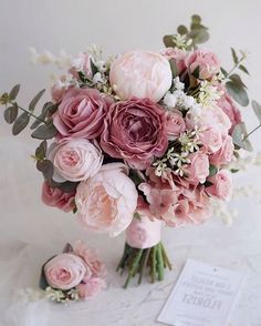 a bridal bouquet with pink flowers and greenery