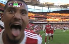 a man making a funny face in front of a crowd at a soccer game with his mouth wide open