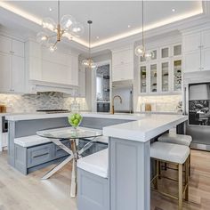 a kitchen with white cabinets and an island table in front of the stove top oven