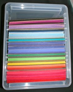 a plastic container filled with lots of different colored thread