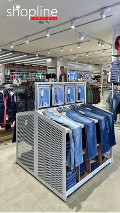 a clothing store with clothes on racks and people looking at them