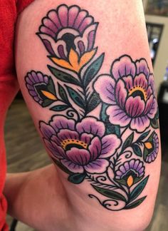 a woman's thigh with flowers painted on the side and in front of her