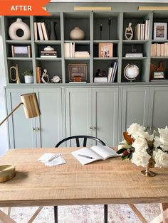 a wooden table topped with white flowers next to a bookshelf filled with books