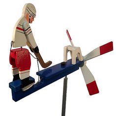 a toy figure is on top of a seesaw with a hockey stick in it's mouth