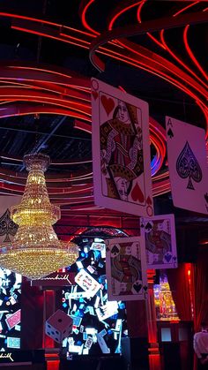 a casino room filled with lots of neon lights and cards on the wall behind it