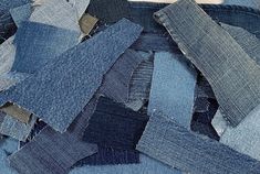 a pile of blue jeans sitting on top of each other