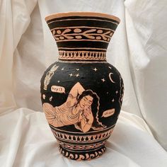 a black and white vase with an image of a woman on the side, surrounded by stars