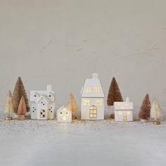 a group of small white houses sitting next to each other on top of a table