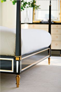 a black and gold bed frame in a bedroom with white carpeted flooring on the side