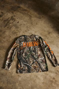 the back of a camo shirt that says,'hunting'in orange on it