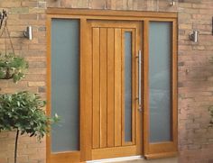 a wooden door sitting next to a brick wall with potted plants on the side