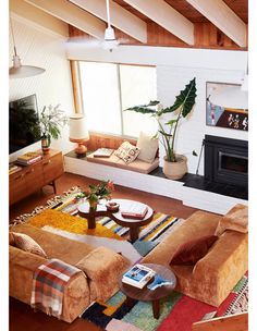 a living room filled with furniture and a flat screen tv mounted on a wall above a fire place