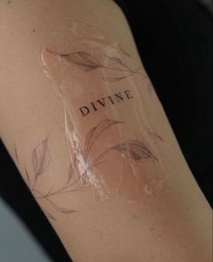 a woman with a tattoo on her arm that says divine