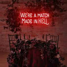 there is a neon sign that says we're a match made in hell on the table