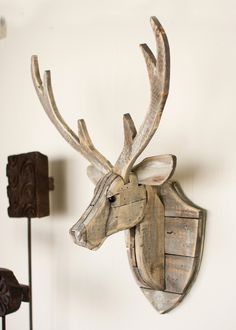 a wooden deer head mounted to the side of a wall