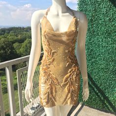 Be The Showstopper In This Dazzling, One Of A Kind Gold Embellished Chain Dress With Plunge Back, Perforated Side Slits And Crystal Appliqus. Gold Embellished V-neck Dress, Gold Embellished Sleeveless Mini Dress, Embellished Backless Cocktail Dress, Backless Embellished Evening Dress For Night Out, Embellished Backless Evening Dress For Night Out, Embellished Fitted Backless Evening Dress, Chic Gold Embellished Mini Dress, Gold Embellished Mini Sequin Dress, Chic Embellished Backless Sequin Dress