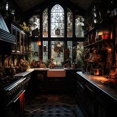 an old fashioned kitchen with lots of pots and pans on the counter top, in front of a large stained glass window