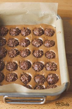 a pan filled with chocolate covered cookies on top of a wooden table