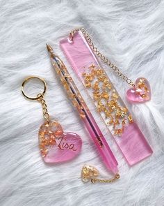 the pink pen is next to two other items on a furnishing area, including a heart shaped keychain